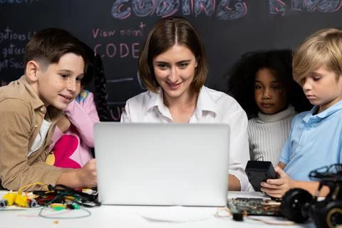 Teacher demonstrate attentive children to code robots in STEM class. Erudition. Stock Photos