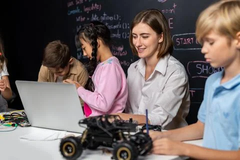 Teacher demonstrate attentive children to code robots in STEM class. Erudition. Stock Photos