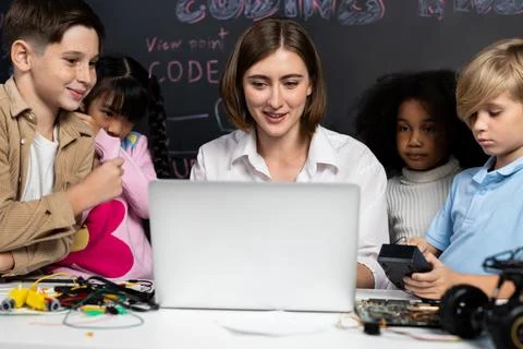 Teacher demonstrate attentive children to code robots in STEM class. Erudition. Stock Photos