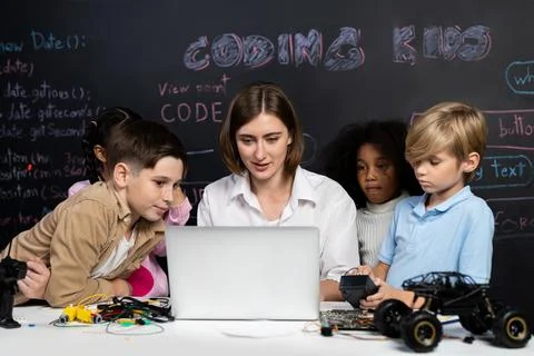 Teacher demonstrate attentive children to code robots in STEM class. Erudition. Foto stock
