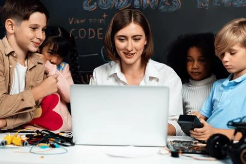 Teacher demonstrate attentive children to code robots in STEM class. Erudition. Stock Photos