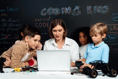 Teacher demonstrate attentive children to code robots in STEM class. Erudition. Stock Photos