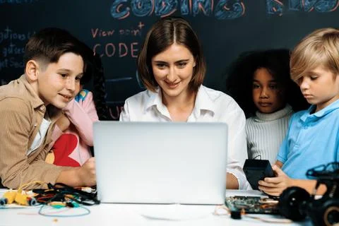 Teacher demonstrate attentive children to code robots in STEM class. Erudition. Stock Photos