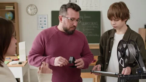Teacher Demonstrating 3D Printed Plastic Phone Holder to Students During Class Stock Footage 335699347