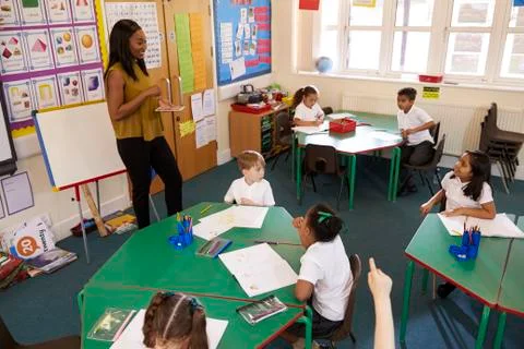 Teacher With Digital Tablet In Elementary School Classroom Stock Photos