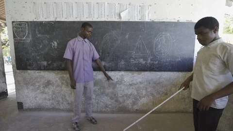 Teacher of disabilities working with blind students in school classroom. Video stock 121456641
