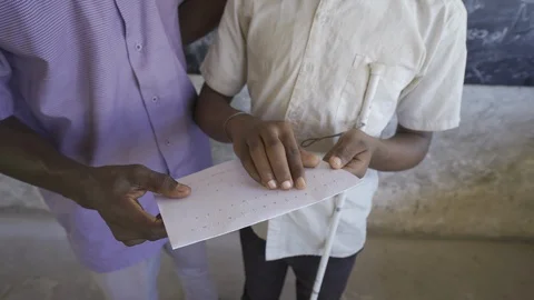 Teacher of disabilities working with blind students in school classroom. Video stock 121457514