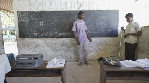 Teacher of disabilities working with blind students in school classroom. Stock Footage 121459909