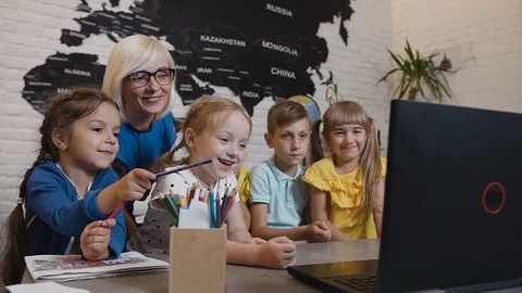 Teacher discussing a computer program with a fun group of pupils. Young woman Video stock 93661725