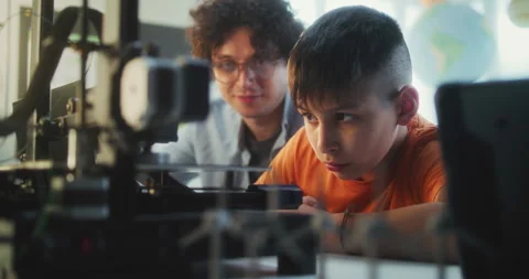 Teacher Educating Programming to Smart Young Boy in Modern Classroom Stock Footage 311675637
