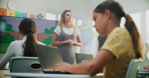 Teacher Educating Young Students. Elementary School Girl Drawing Picture on Stock Footage 315471736