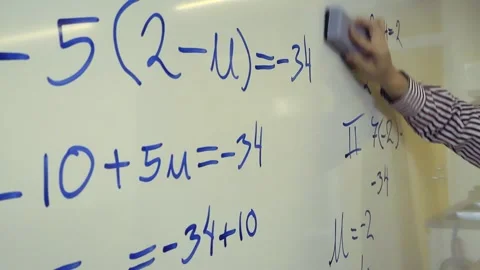 Teacher erasing mathematical equations from a whiteboard Stock Footage 344105434