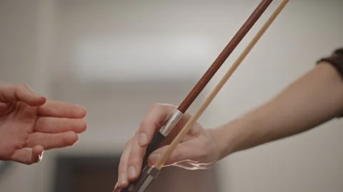 Teacher expertly demonstrating controlled bow passing to student. Closeup of Vídeo Stock 347516990