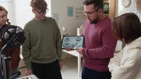 Teacher Explaining 3D Models on Tablet to Students in Modern Classroom Stock Footage 335698694