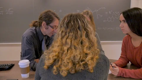 Teacher explaining answers to math and science problems to students in classroom Stock Footage 102852232