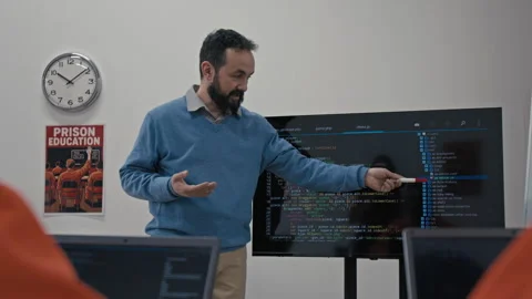 Teacher Explaining Computer Code Structure to Convicts at Lesson in Jail Stock Footage 314054839