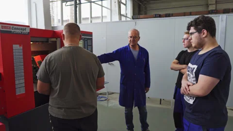 Teacher explaining how to use a Computer Numerical Control milling machine Video stock 198827193