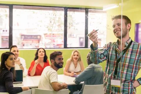 Teacher explaining the lesson to his students. Stock Photos