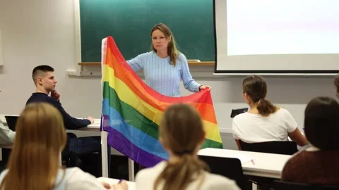 Teacher explaining meaning of LGBT flag to students in school Stock Footage 269865023