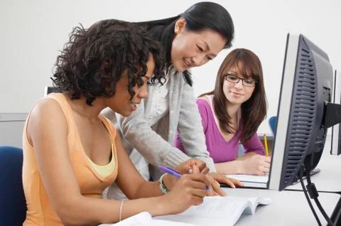 Teacher Explaining Notes To Female Students Stock Photos