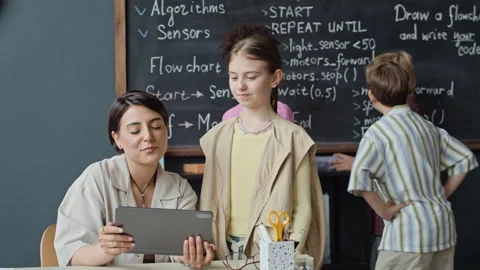 Teacher Explaining Robotics Lesson to Student Using Tablet Stock Footage 339199992