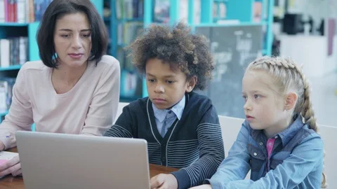 Teacher explaining students how to do tasks on laptop Stock Footage 108746211