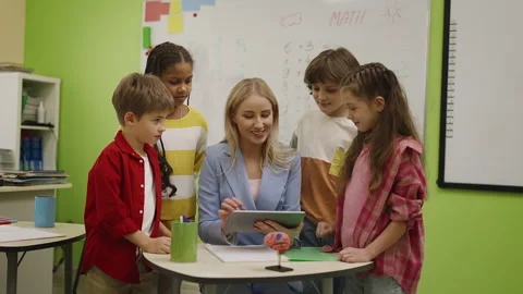 Teacher explaining task to pupils using tablet in smart classroom learning Stock Footage 333585441