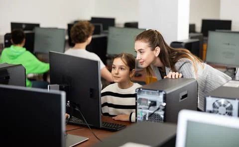 Teacher explaining task solution to pupil during computer science lesson Foto stock