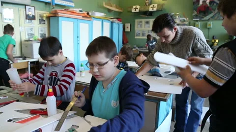The teacher explains to the boy how to make a model airplane Stock Footage 59112868
