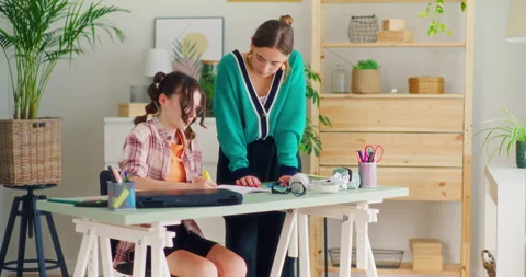 Teacher Explains a Difficult Task to the Student and Helps Her During the Lesson Stock Footage 277127179