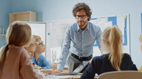 Teacher Explains Lesson to a Classroom Full of Children Having Discussion Stock Footage 119561743