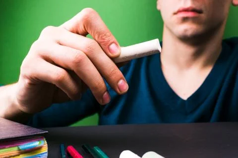 The teacher explains the topic with chalk in hand. Close-up. The concept of t Stock Photos