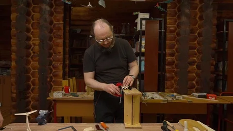 Teacher fixes wooden plane engine model to metal vice 스톡 동영상 127112608
