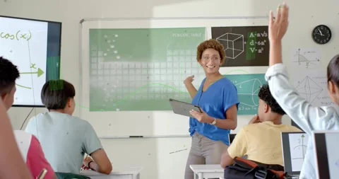 Teacher gesturing tablet and asking in math class, class raising hands, formulas Stock Footage 330955626