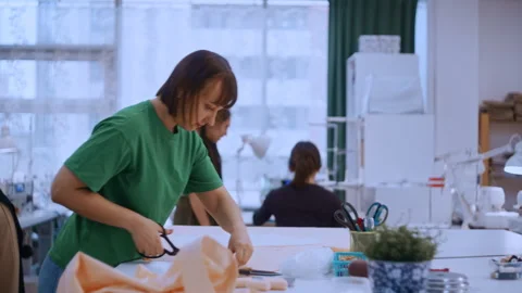 Teacher giving scissors to student in sewing school 動画素材 335931252
