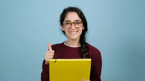 Teacher with glasses evaluetes her students on a blue background Stock Footage