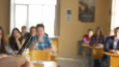 Teacher with a group of high school students in classroom. View from the hands Stock Photos