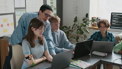 Teacher Guiding her Students, Using Laptops During IT Class in School Stock Footage 317639873