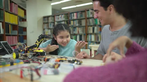 A teacher guiding students in a robotics project during a STEM class Stock Footage 320787289