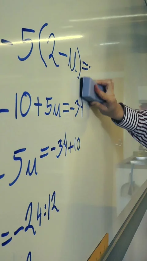 Teacher hand erasing math formula on whiteboard Stock Footage 345550824