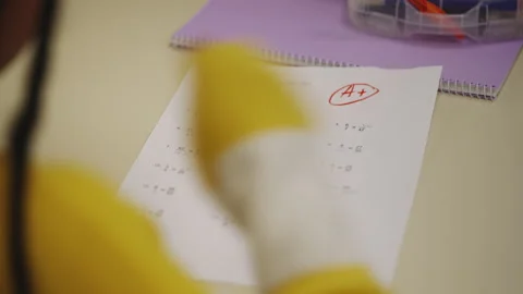 Teacher handing out math test paper to girl celebrating excellent grade Stock Footage 335683217