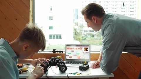Teacher help student fixing car model and giving advise at class. Edification Stock Footage 267612865