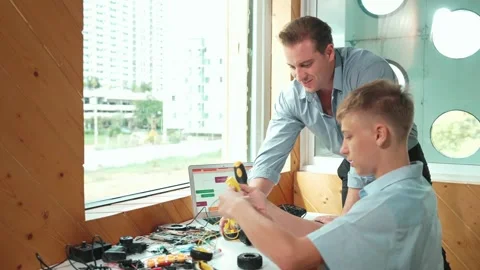 Teacher help student fixing car model and giving advise at class. Edification Stock Footage 273385005