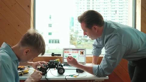 Teacher help student fixing car model and giving advise at class. Edification Stock Footage 274385751
