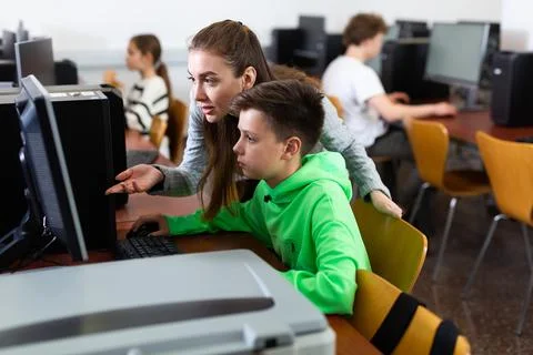 Teacher helping boy to solve computer problem Stock Photos