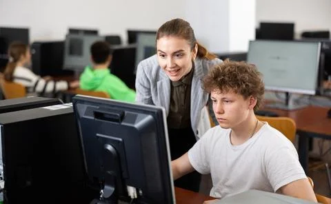 Teacher helping boy to solve computer problem Stock Photos