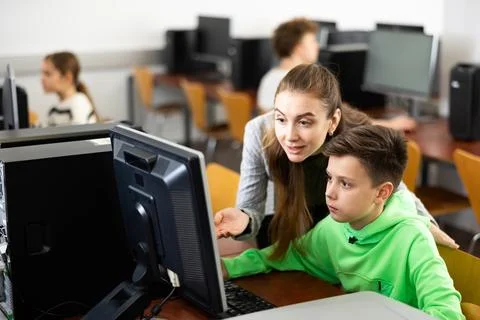 Teacher helping boy to solve computer problem Stock Photos