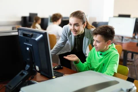 Teacher helping boy to solve computer problem Stock Photos