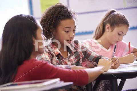 Teacher helping elementary school pupils in class Stock Photos
