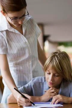 Teacher helping elementary school student in class Stock Photos